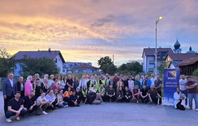 Poslovna grupa ispred zgrade, plavi banner, večernja fotografija u Krušnici, Bosna i Hercegovina.