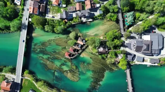 Mirna rijeka Krušnica u Bosni i Hercegovini, okružena zelenilom i mostovima.