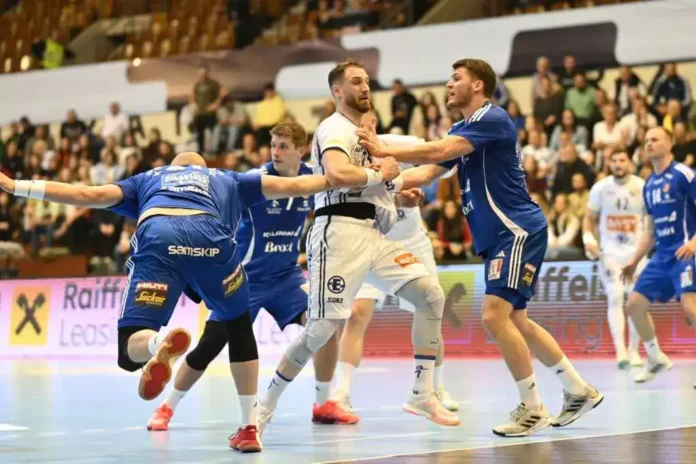 Akcija na utakmici rukometa, igrači u borbi tokom meča u sportskoj hali.