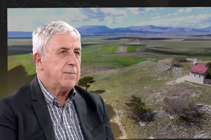 Mirni pejzaž Krušnica s planinama i poljima u pozadini.