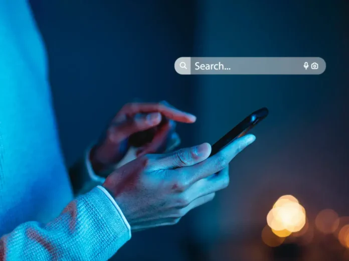 Moderna osoba koristi smartphone u noćnim uvjetima, što ilustrira upotrebu tehnologije u svakodnevnom životu.