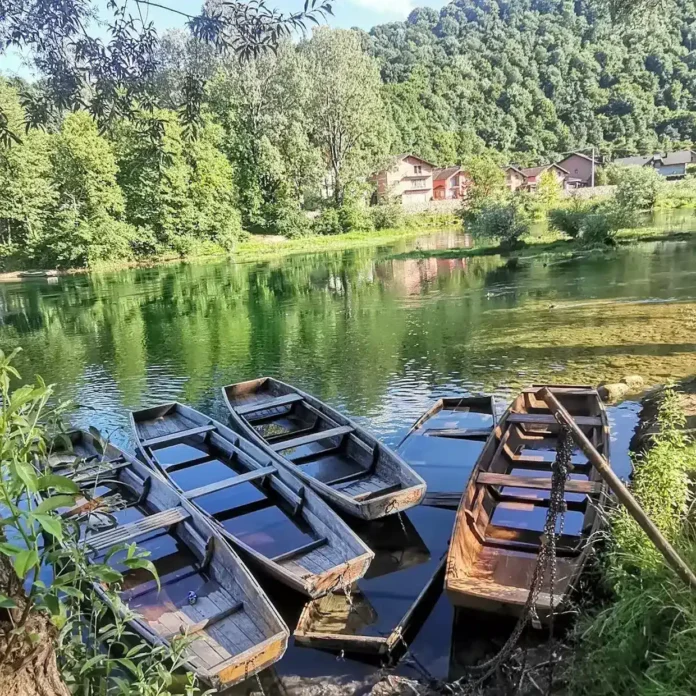 Mirno jezero sa drvenim čamcima i zelenilom, okolna sela u prirodnom okruženju Krušnice.