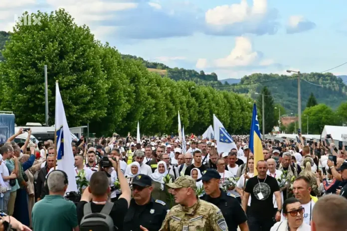 1. Alternativni tekst: Veliki skup ljudi s bosanskim zastavama i policajcima na proslavi.
