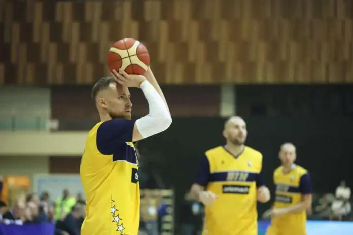 1. Košarkaš u žuto-plavoj uniformi s loptom u ruci na terenu.