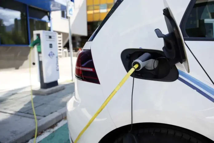 Punjenje električnog automobila na punjaču u gradu.