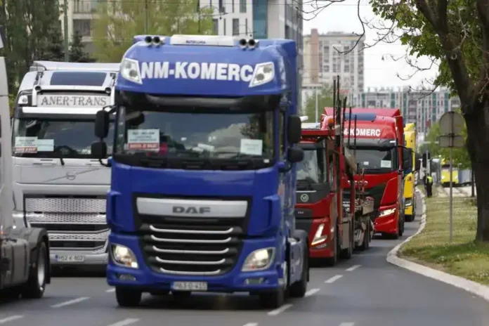 Kamioni na putu u urbanom okruženju, sa oznakama i bojama, u prolazu kroz grad.