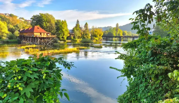 Mirna okolina rijeke Krušnica sa kućama na obali i zelenilom.