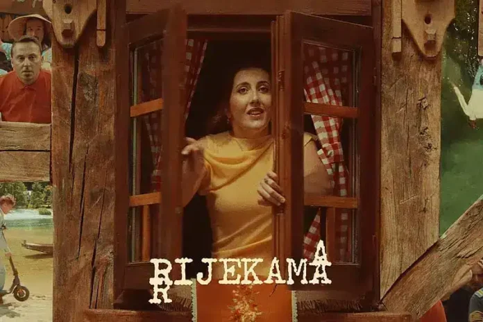 Žena kroz prozor drvene kuće na festivalu Biljeka u Krušnici.
