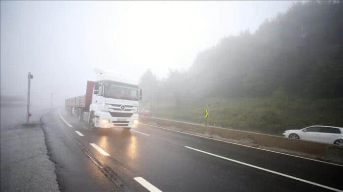 Nafta na putu u magli, kamion i automobil voze kroz izazovno vremenske uvjete na magistralnom putu.