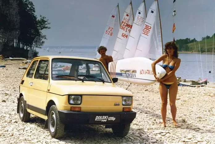 Bijela bickl, automobilska scena na plaži sa jedrima i plivačima, vintage odmor u Bosni i Hercegovini.