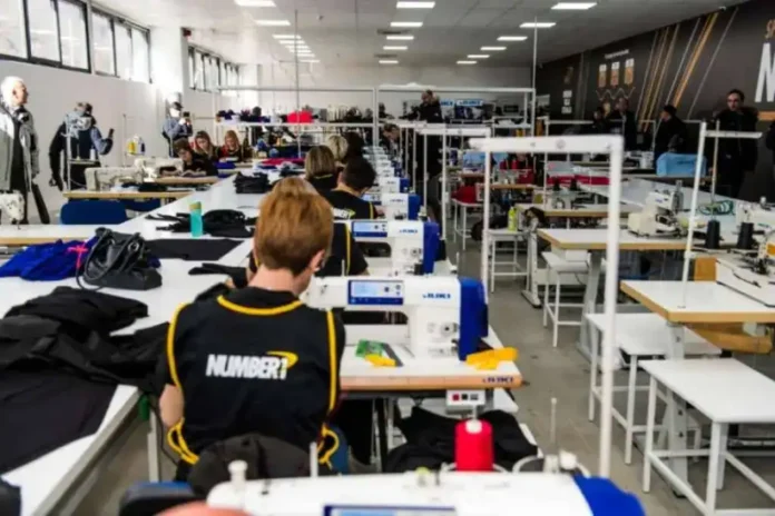 Malo radno okruženje u tekstilnoj fabrici ili radionici sa strojevima za šivenje.