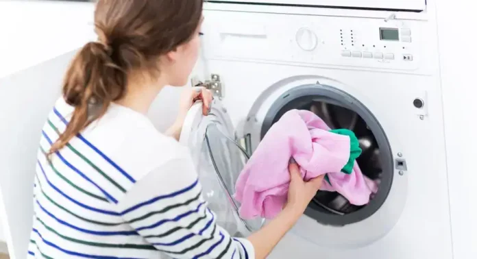Brza žena pere odjeću u modernoj mašini za pranje rublja.