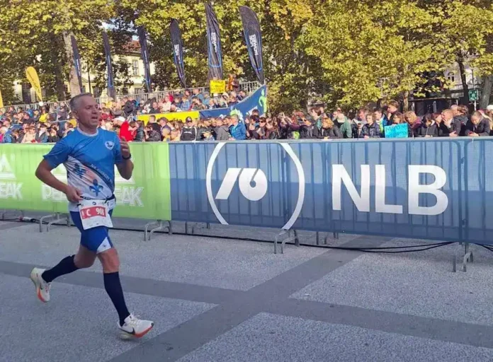 Atl text: Trkač na maratonu u Banjoj Luci, završava utrku pored publike i plakata.