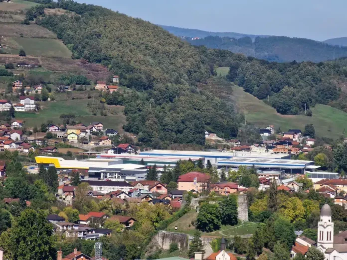 Bospan pogled na Krušnicu, jedinstveni gradić u Bosni i Hercegovini, okružen zelenim brdima i naseljenim kućama.
