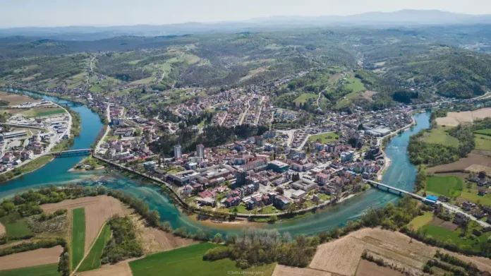 Alt: Krušnica, panorama grada sa rijekom i zelenilom.