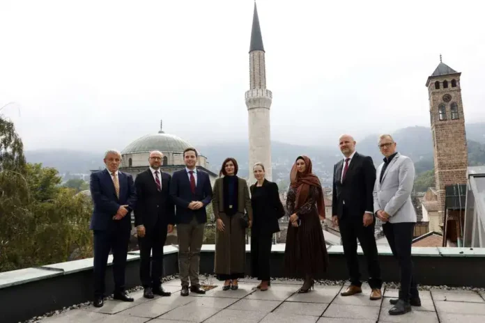 Političari i poslovni ljudi na terasi sa pogledom na grad i džamiju u Krušnici, Bosna i Hercegovina.