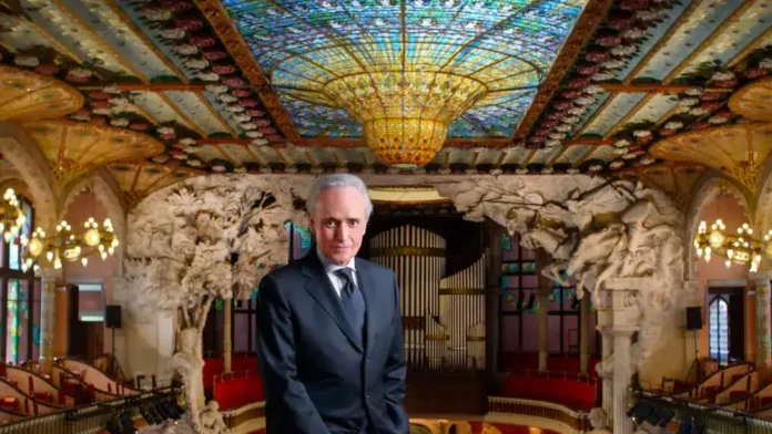 - Elegant man in suit standing inside ornate theater with intricate decor.