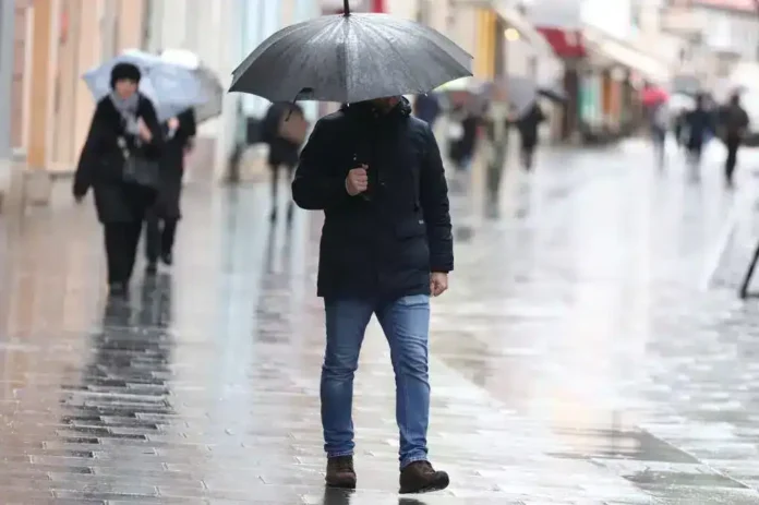 1. Čovjek sa kišobranom na kišnom gradskom trgu u Krušnici.
