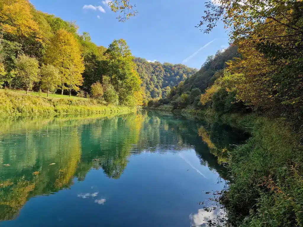 Mirna rijeka okružena jesenjom šumom u prirodnom okruženju Krušnice.