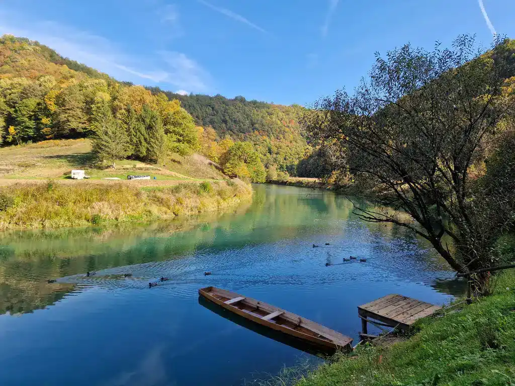 Krušnica rijeka u prirodi, zelena šuma i plavo nebo, mirno okruženje za odmor i rekreaciju.