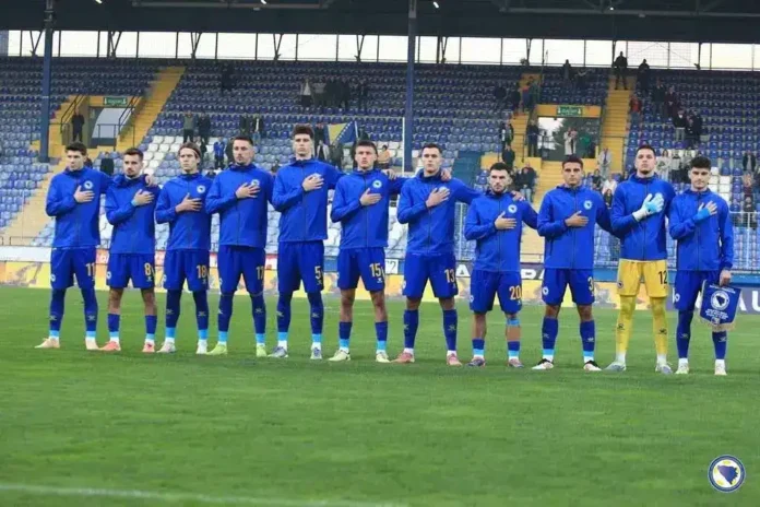 Refleksija fudbalske reprezentacije na terenu, srca ruka na srcu, sportska atmosfera, timski duh.