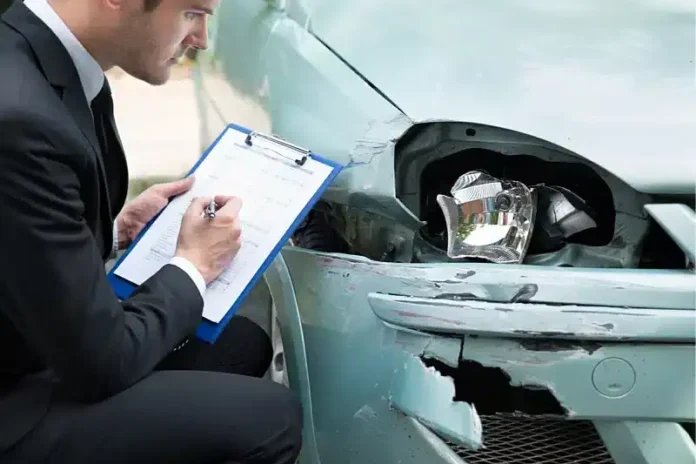 Oštećen automobil nakon sudara, policijski službenik sa zapisnikom.