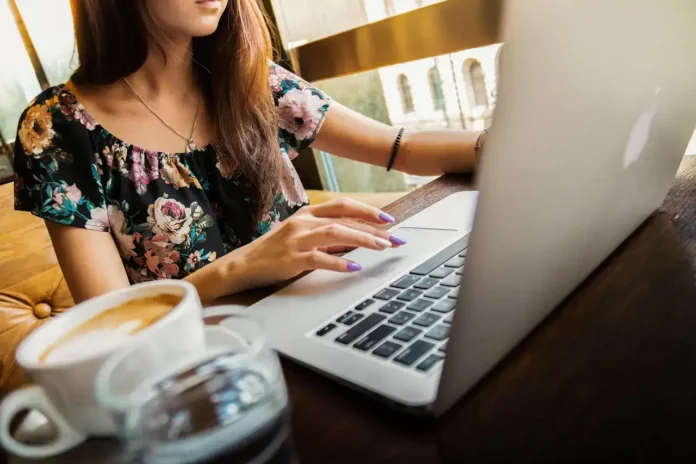 Laptop u kafiću sa šoljom kafe, rad od kuće, online posao, rad na računaru, moderni radni prostor.