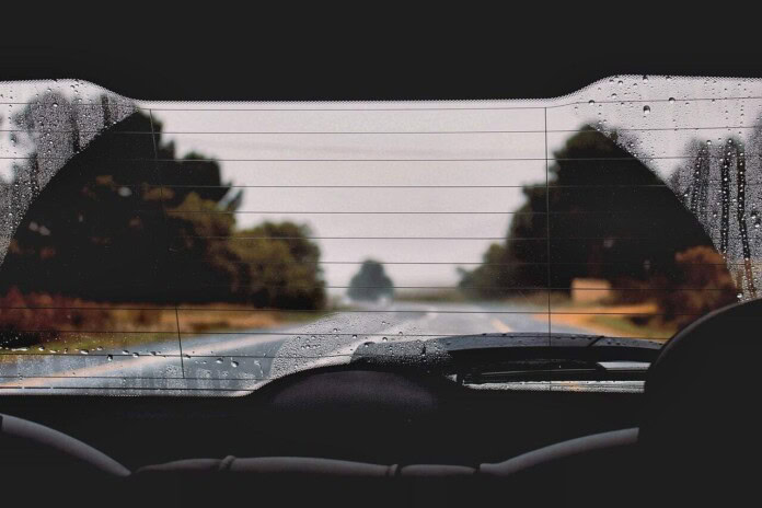 Mokar retrovizor na automobilu, kiša i vožnja kroz selo ili prirodu.
