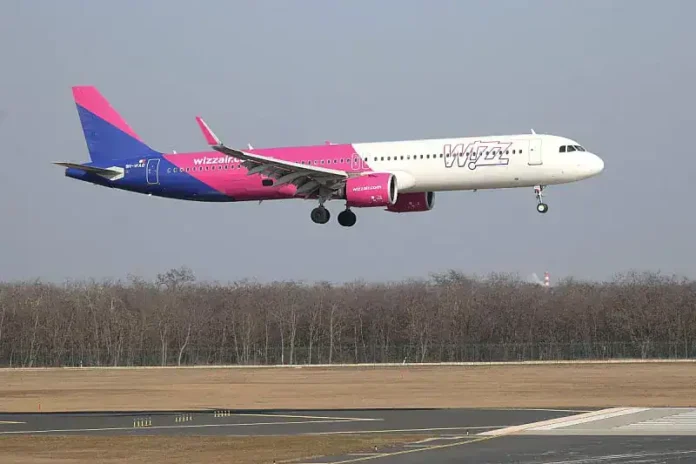 1. Avion Wizz Air u letu nad zemljom, blizu aerodroma.