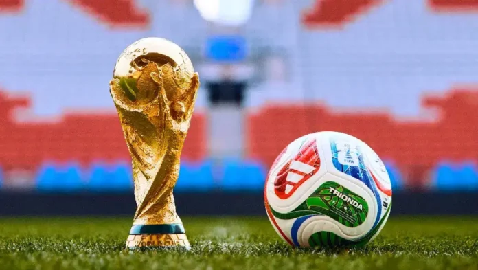 Golden World Cup trophy and soccer ball on the field, representing sports and football excellence.