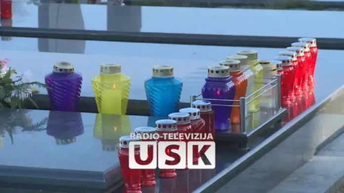 Raznobojne svijeće na stolu kod rijeke Krušnica, mirna i slikovita scena.