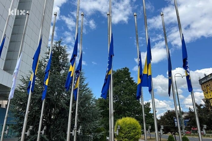 Blue and yellow flags outside building on sunny day.