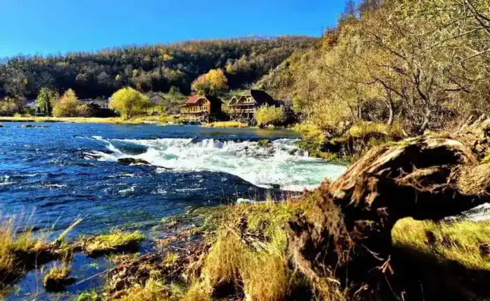 Krušnica rijeka okružena prirodom i kućama u planini.