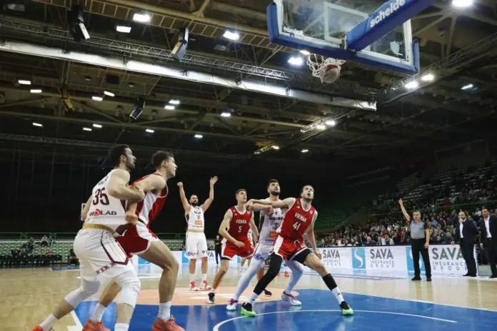 Gledanje na odbojkaši tim u akciji tokom utakmice u dvorani.