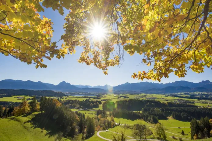 Prelijepa scena Krušnice s zelenim poljima, šumama i planinom u sunčano jesenje vrijeme.