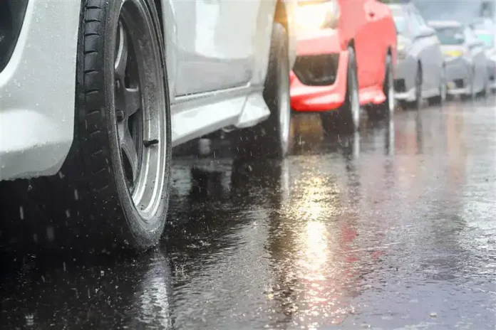 Mokra ulica sa parkiranim automobilima tokom kiše.