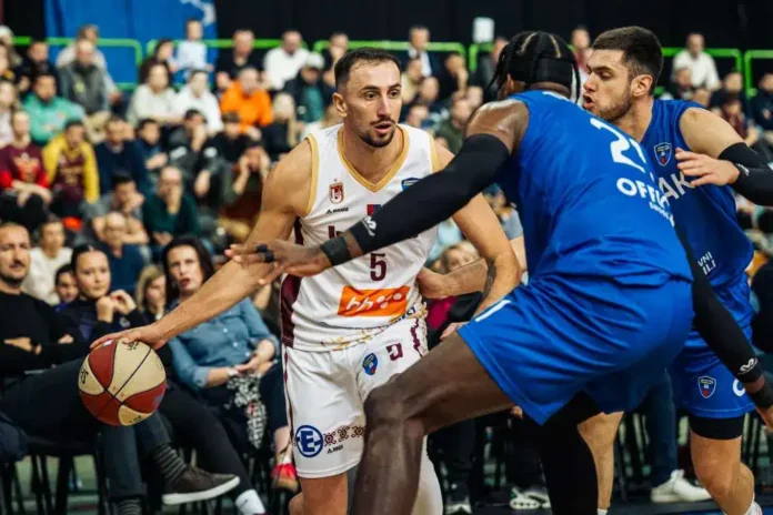 NBA košarkaška utakmica u dvorani, igrači u akciji, publika u pozadini.
