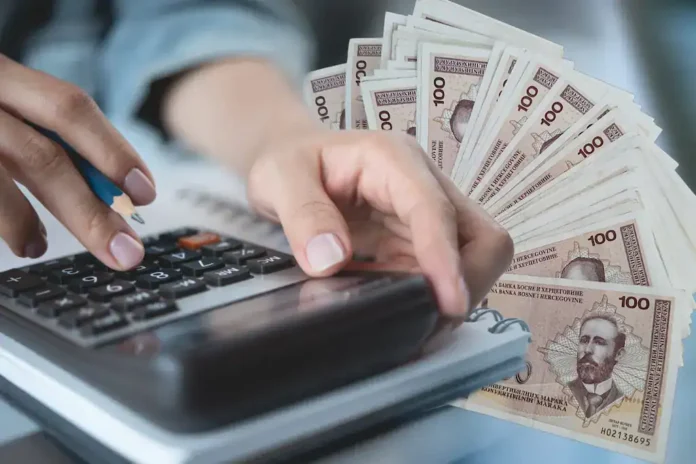 100 KM novac, računalo i kalkulator, finansijsko upravljanje, ekonomija, finansije, Bosna i Hercegovina, novac na desktopu, poslovni finansijski troškovi, bankovni poslovi.