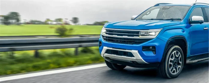 Moderna plava SUV automobil na autoputu, dinamički u pokretu, sa zelenim pejzažem u pozadini.