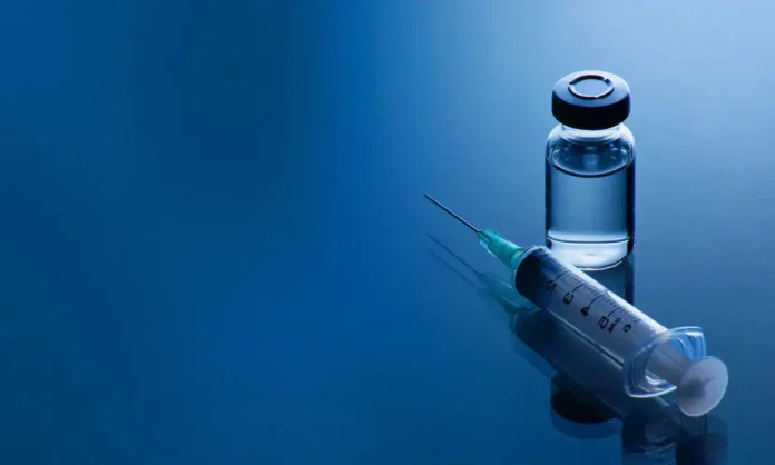 Ampula s vakcinom i igla za injekciju, medicinska oprema, vakcinacija, zdravstvena zaštita.