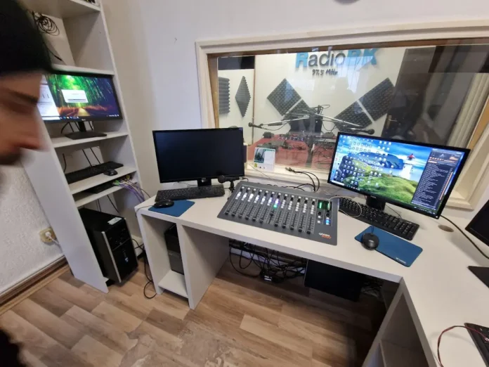Radio studio s opremom i mikrofonskim uređajima za emitiranje.