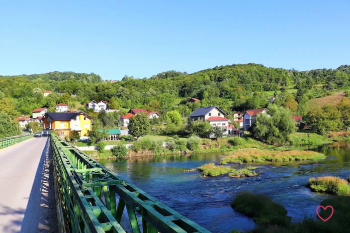 Prekrasan pogled na rijeku i selo u Bosanskoj Krupi pod vedrim nebom.