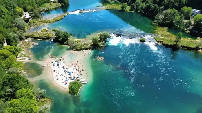 Krušnica rijeka s čistom vodom i plažom u prirodi.