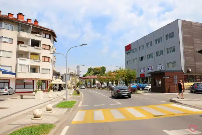 Ulica u Bosanskoj Krupi s modernim zgradama i pješačkim prijelazom.