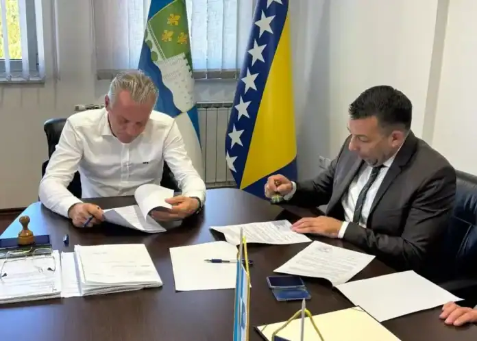 Dva muškarca potpisuju dokumente za projekt na Krušnici.