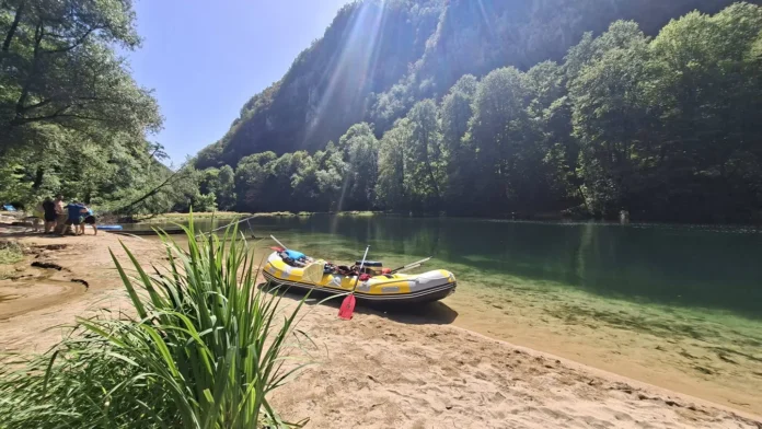 Krušnica rijeka s čamcem na obali i zelenom okolinom.