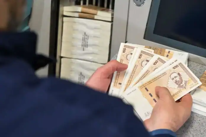 Osoba s novčanicama od 100 KM u banci.